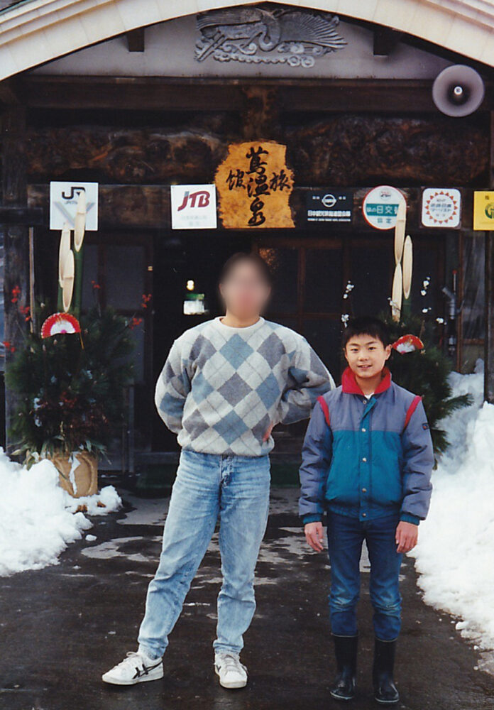 温泉旅館のエントランスの前で、お兄さんとともに、青年期の山本先生